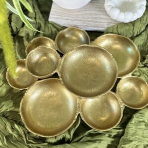 A group of gold plates sitting on top of green cloth.